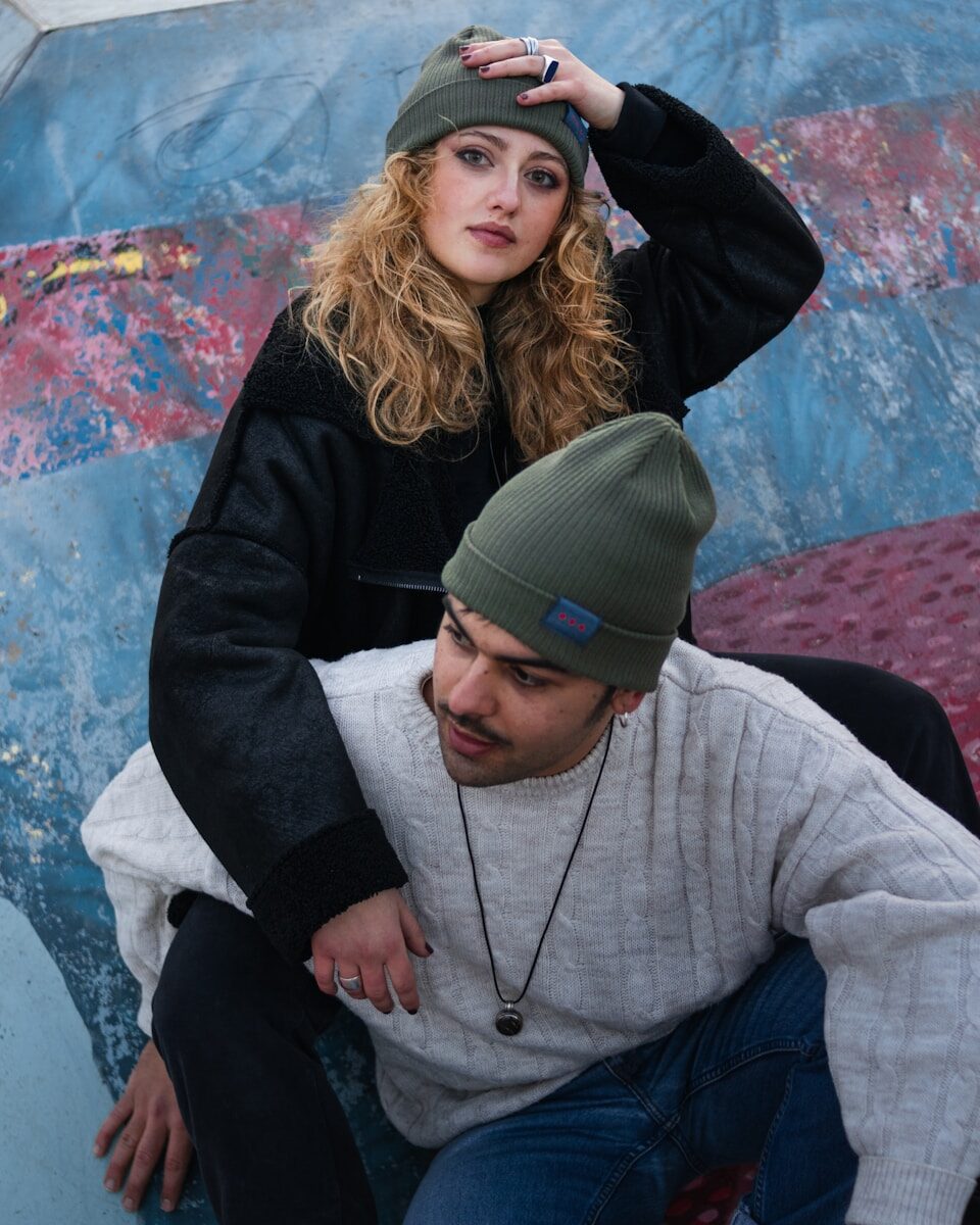Photo by Mirko Mina man in gray sweater hugging woman in black jacket